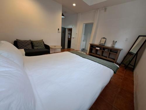 1 dormitorio con 1 cama blanca grande y 1 sofá en Maluda B&B en Taimali