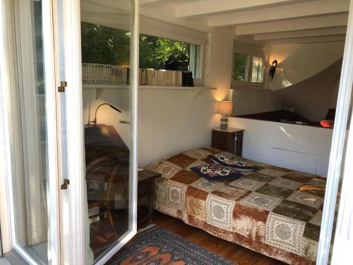 a small bedroom with a bed and a window at Les Cyprès in Vevey