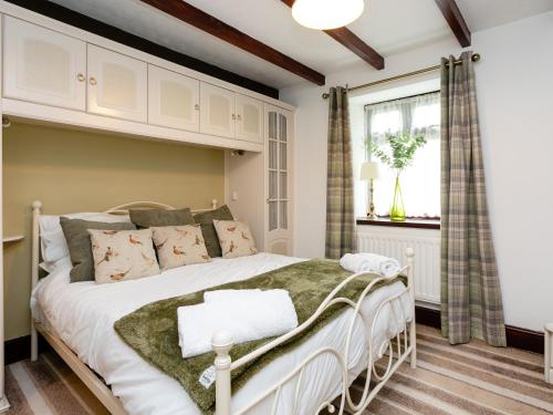 a bedroom with a bed and a window at Aryarch in Eglingham