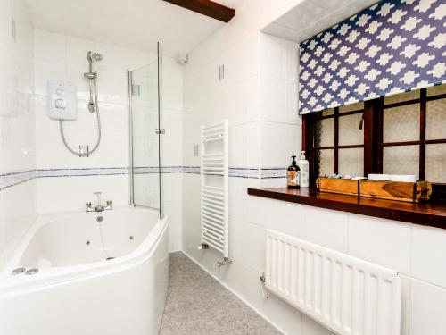 a bathroom with a bath tub and a shower at Aryarch in Eglingham
