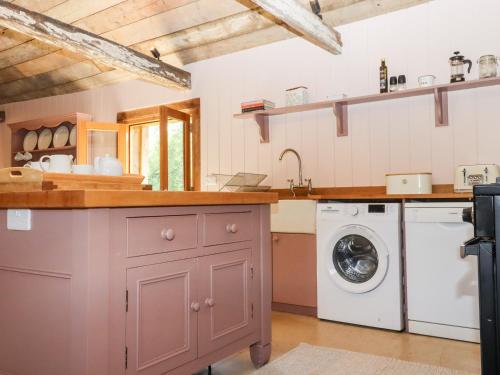 een keuken met een wasmachine en droger bij The Stone Barn in Ticehurst