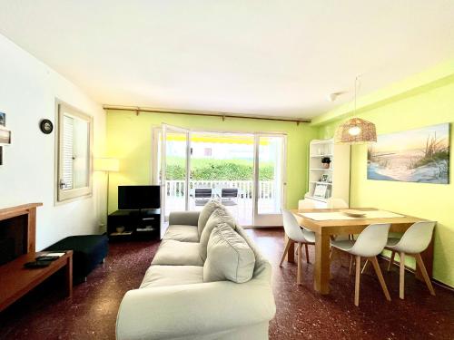 ein Wohnzimmer mit einem weißen Sofa und einem Tisch in der Unterkunft Adosado Ripolles in Tarragona