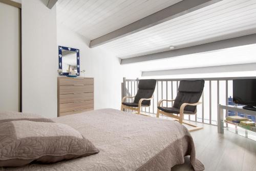 um quarto com 2 cadeiras numa varanda em Studio "Palombe" dans résidence avec piscine em Saint-Martin-de-Ré
