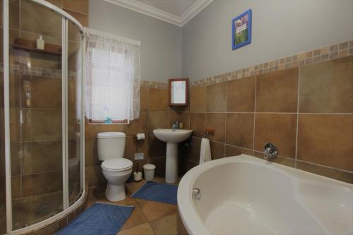 a bathroom with a tub and a toilet and a sink at Tuksumduin in Ballito