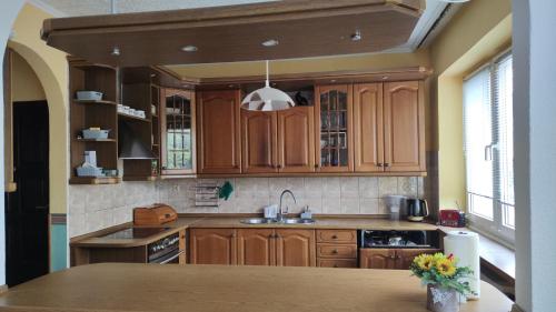 a kitchen with wooden cabinets and a sink at MIESZKANIE - DOM 200 m od MORZA in Dziwnów