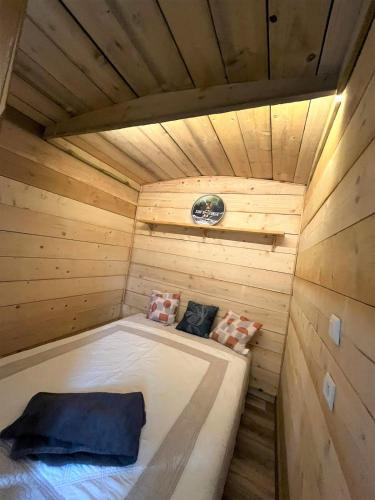 un lit dans un sauna en bois avec deux oreillers dans l'établissement La Cabane de Mercone Crenu, à Corte