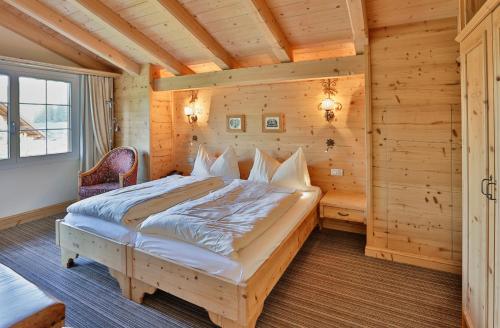 a bedroom in a log cabin with a bed at ERMITAGE Wellness- & Spa-Hotel in Gstaad