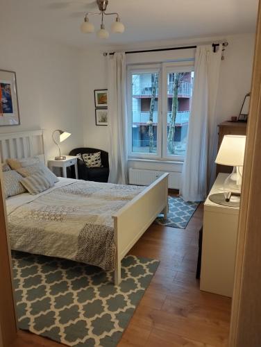 een slaapkamer met een bed en een raam bij Apartament w Kołobrzegu z basenem in Kołobrzeg