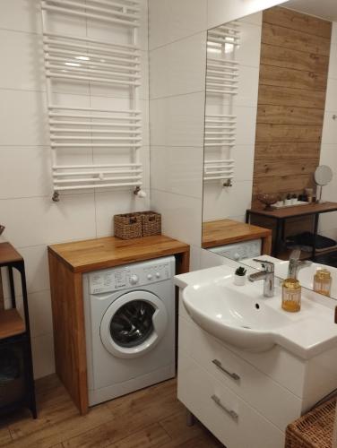 een keuken met een wasmachine en een wastafel bij Apartament w Kołobrzegu z basenem in Kołobrzeg