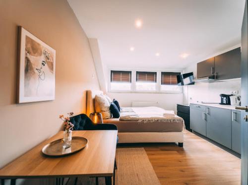 a room with a bed and a table and a kitchen at Premium Apartments Koblenz in Koblenz