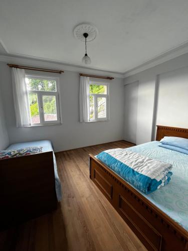 - une chambre avec un lit et 2 fenêtres dans l'établissement Gunguli Pansiyon, à Kukunat
