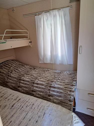een slaapkamer met een bed met een gordijn en een raam bij Lini Guest House in Nīca