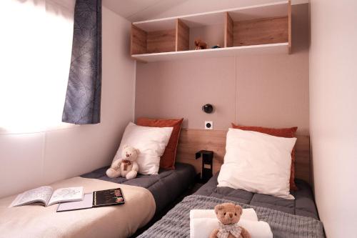 two beds in a small room with two teddy bears at L'Orée de l'Océan - Vendée in Landevieille