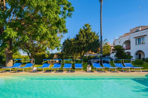 a group of blue chairs sitting next to a swimming pool at Villa Luritu Luxury Pool Tricase by HDSalento in Tricase