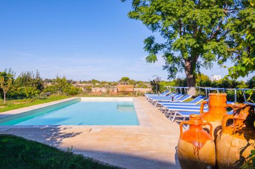 a swimming pool with a bunch of vases next to it at Villa Luritu Luxury Pool Tricase by HDSalento in Tricase