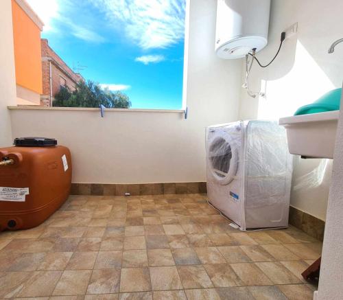 uma lavandaria com uma máquina de lavar roupa e uma janela em Civico 14 Apartment 2 em Monserrato