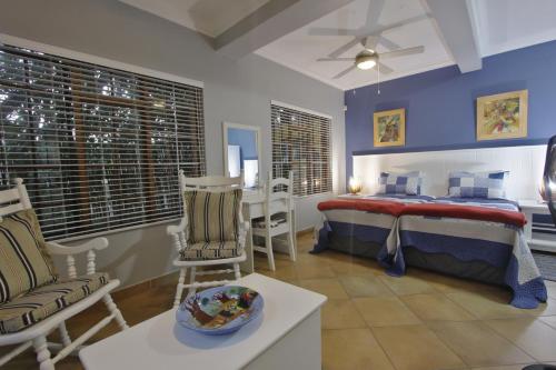 a bedroom with a bed and a table and chairs at Tuksumduin in Ballito