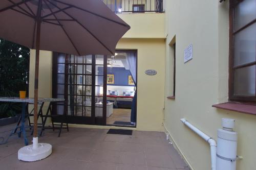 a patio with an umbrella in front of a building at Tuksumduin in Ballito