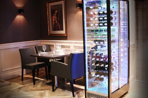 a dining room with a table and a wine cellar at Red Hall Hotel in Walmersley