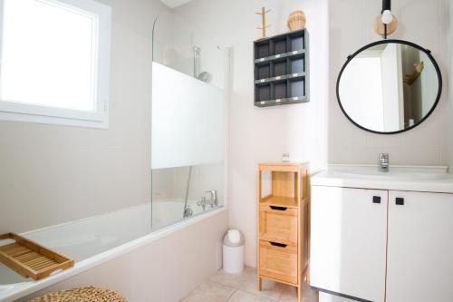 une salle de bain avec une baignoire, un lavabo et un miroir dans l'établissement AGAPANTHES Jolie Maison proche Plage et Commerces, au Bois-Plage-en-Ré
