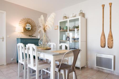 une salle à manger avec une table et des chaises blanches dans l'établissement AGAPANTHES Jolie Maison proche Plage et Commerces, au Bois-Plage-en-Ré