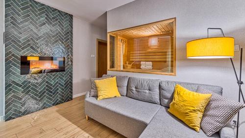 sala de estar con sofá y chimenea en Apartamenty przy Gondoli - Źródlana 2 by Royal Aparts, en Świeradów-Zdrój