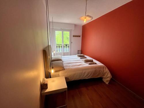 ein Schlafzimmer mit einem großen Bett mit einer roten Wand in der Unterkunft Bel appartement Samoëns 72m2 in Samoëns