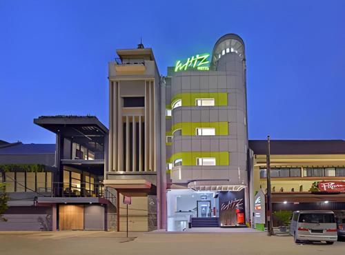 a building with a sign on the side of it at Whiz Hotel Falatehan Jakarta in Jakarta