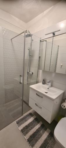 a bathroom with a white sink and a shower at Apartments Orlić in Sali