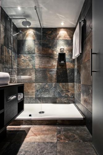 a bathroom with a shower and a bath tub at M Hotel in Genk