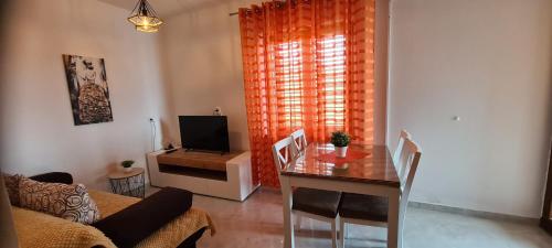 a living room with a dining table and a television at Apartments Orlić in Sali