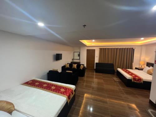 a hotel room with two beds and a couch at Island Wanderers Inn in Coron