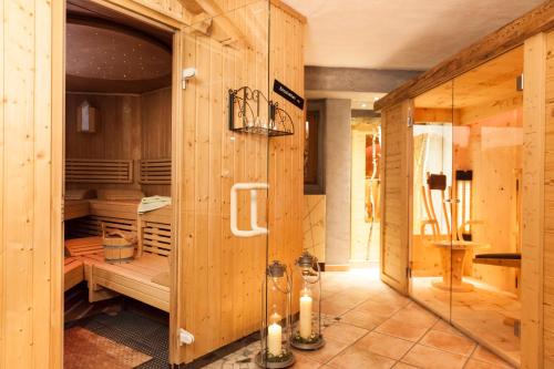 a bathroom with a shower in a room with wooden walls at Fiakerhof in Garmisch-Partenkirchen