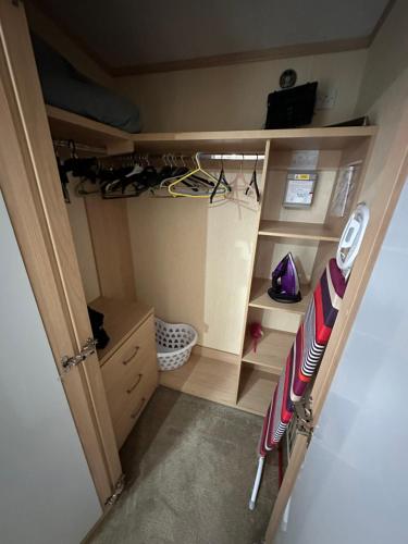a room with a closet with a baseball bat and a shelf at Sunnymede I14 Keyshare holiday lets 6 Berth in Ingoldmells