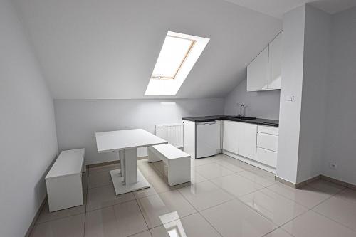 a white kitchen with a table and a skylight at Agropex in Lublin