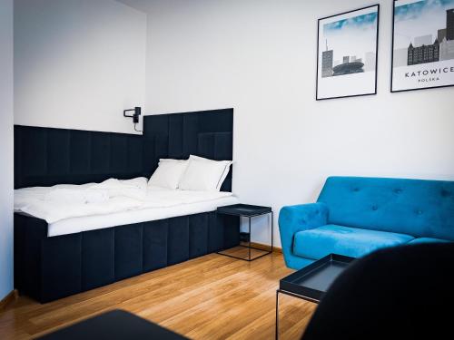 una camera con un letto e un divano blu di Black&White Apartment 8 a Katowice