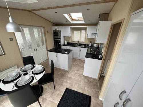 a kitchen and dining room with a table and chairs at Sunnymede Ingoldmells Keyshare holiday lets in Ingoldmells