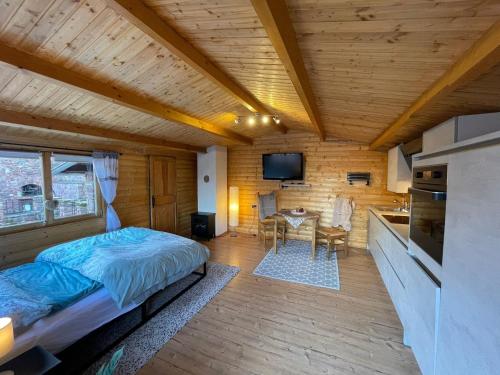 1 dormitorio con 1 cama en una habitación con cocina en Holzhäuschen, en Nideggen