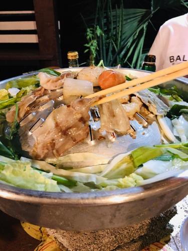 a bowl of food with chopsticks on top at Baan Dongsak River view in Sangkhla Buri