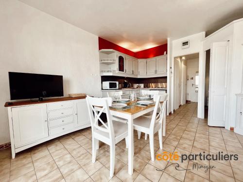 Il comprend une cuisine avec une table et des chaises ainsi qu'une télévision. dans l'établissement AU PETIT LOGIS - Apt T1 Bis avec terrasse à 500m de l'Océan, à Mimizan