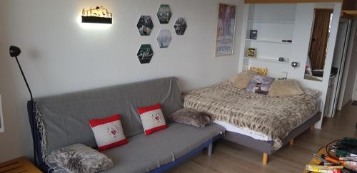ein Wohnzimmer mit einem Sofa und einem Bett in der Unterkunft Anzère Studio 2-4 personnes in Anzère