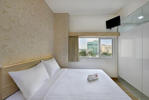 niewielka sypialnia z łóżkiem i oknem w obiekcie Whiz Hotel Falatehan Jakarta w Dżakarcie