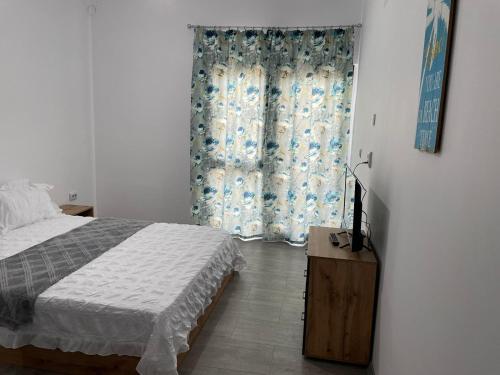 a bedroom with a bed and a window with curtains at Vila B&P in Costinesti