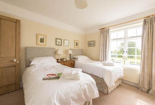 a bedroom with two beds and a window at Hearn Lodge in Nether Stowey