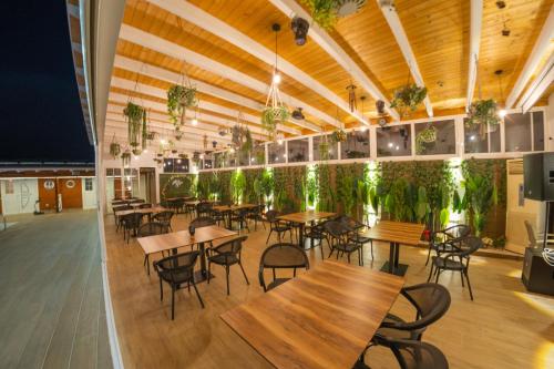 Un restaurante con mesas, sillas y plantas. en Villa Bianca, en Rubjekë