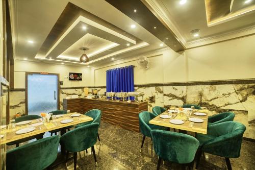 a restaurant with wooden tables and green chairs at SM Royal Stay Hotel - Near Bangalore international Airport in Bengaluru