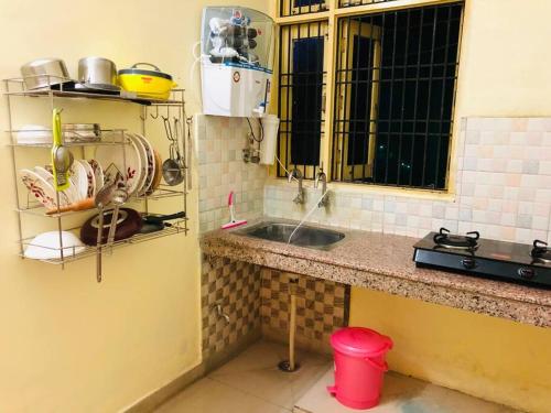 uma cozinha com um lavatório e uma bancada em The Emerald House em Varanasi