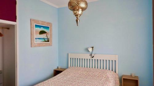 1 dormitorio con cama y lámpara de araña en Casa Limão, en Azinhal