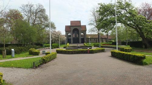 a park with a building with a fountain in front of it at B&B Ferdivedaasje in Dokkum