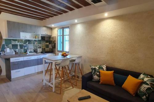een woonkamer met een bank en een tafel in een keuken bij Appartement dans Mas Provençal in Châteaurenard